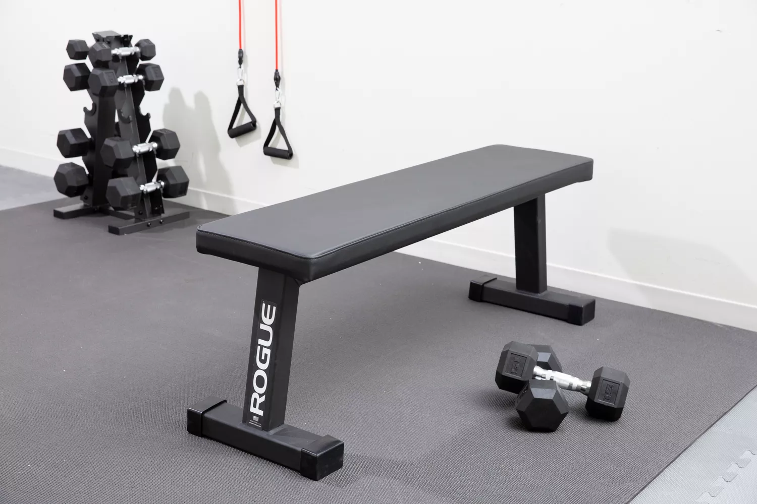 Rogue Fold-Up Utility Bench set up with weights next to it