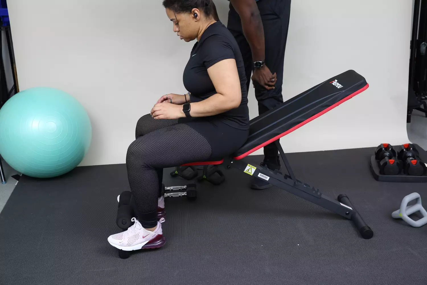 Person sitting upright on the PASYOU Adjustable Weight Bench