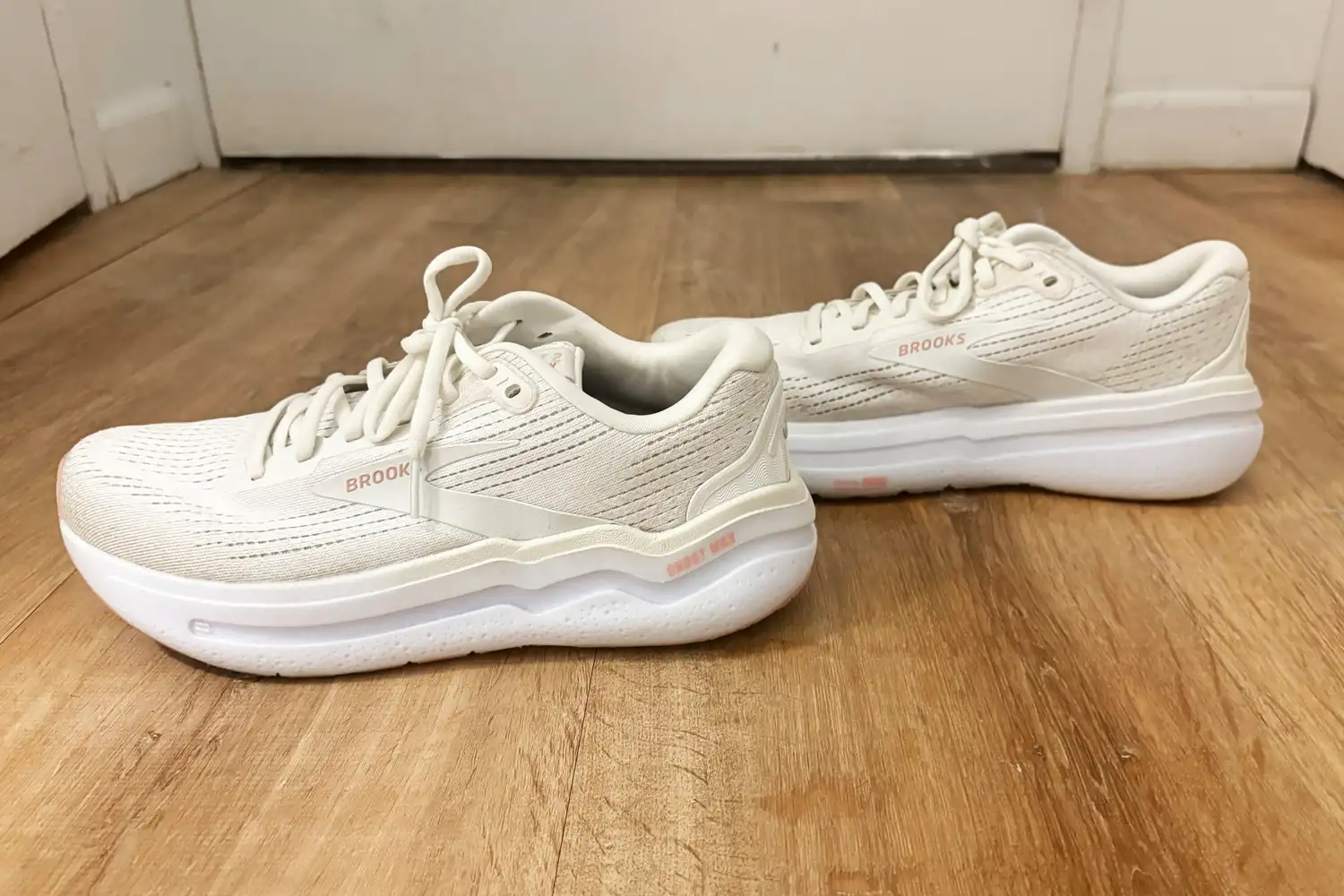 A pair of Brooks Ghost Max 2 Shoes sneakers placed on a wooden floor
