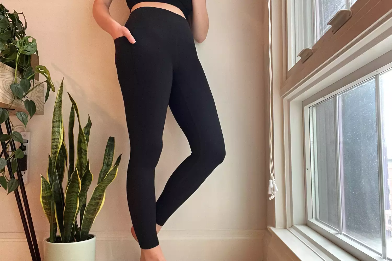 A person stands while wearing the Athleta Transcend Stash Tight